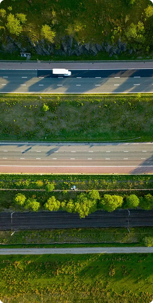 Aerial view of a highway and rail line running through green fields