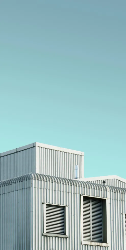 Corrugated metal building against a clear teal sky