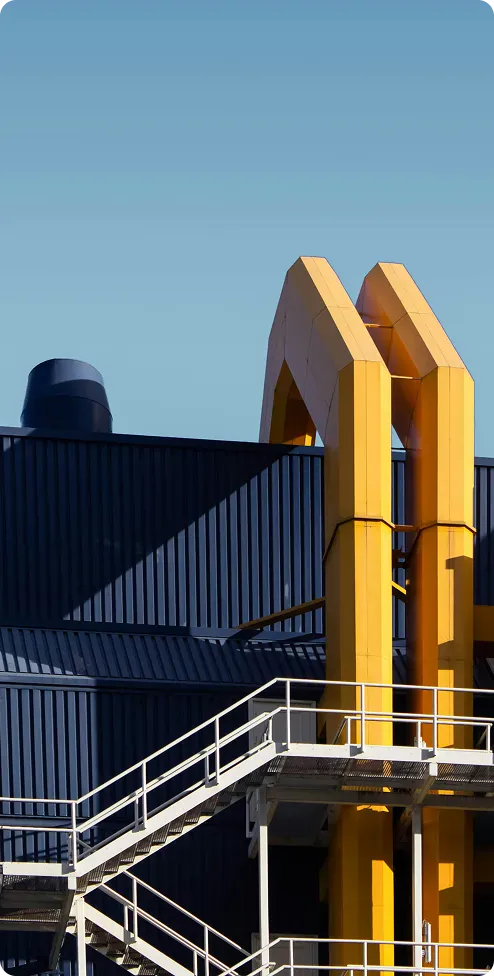 Industrial facility with yellow loading chutes against a navy warehouse