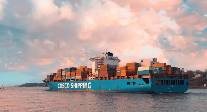 Loaded COSCO Shipping container vessel underway at dusk